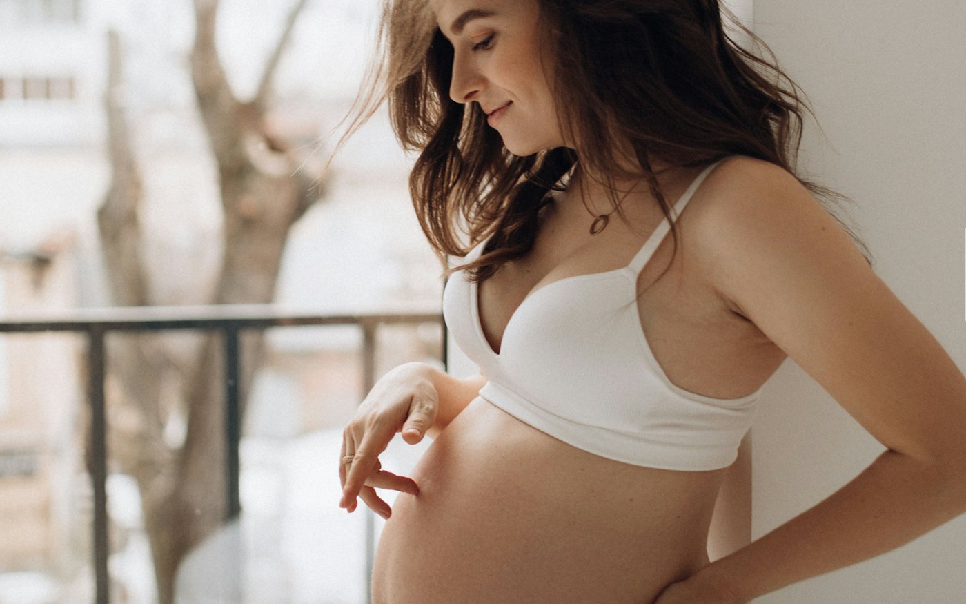 Femme enceinte détendue, les mains posées sur son ventre